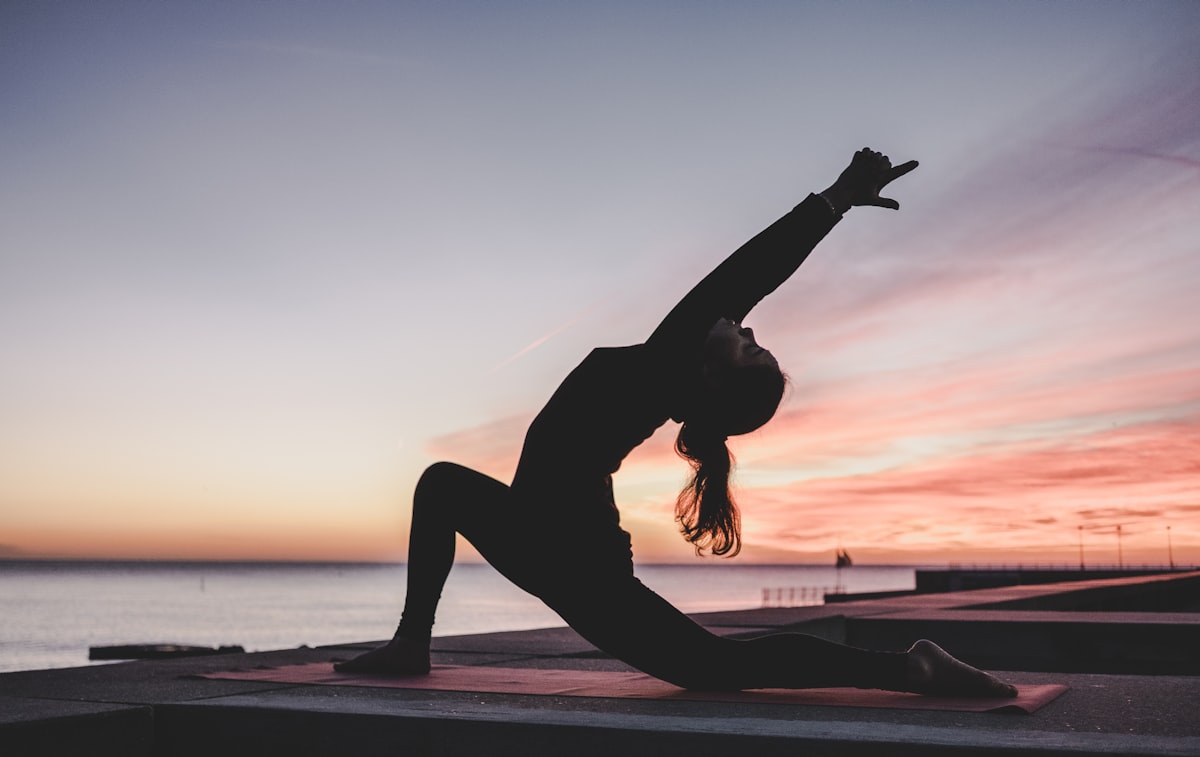 Woman in a calm yoga stretch in a softly lit studio